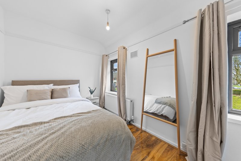 Bright bedroom with double bed, wooden floor, and four-poster bed frame by window