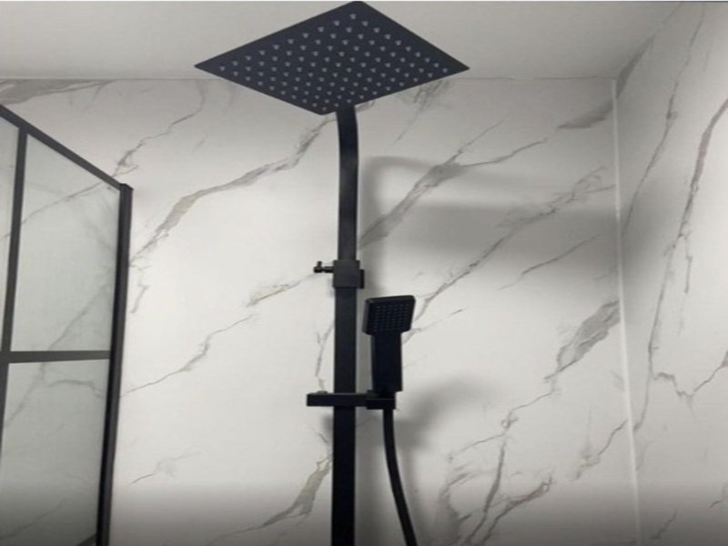 Modern bathroom with marble-effect tiles, rainfall showerhead, and glass shower enclosure