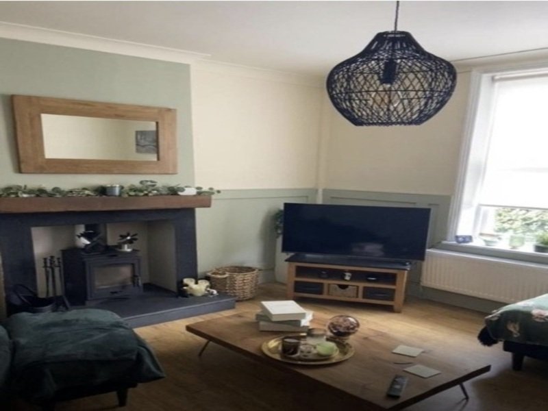 Living room with fireplace, wood-burner, TV stand, pendant lamp and seating area