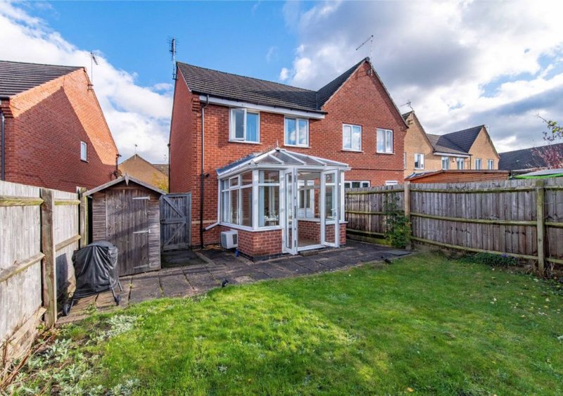 Brick detached house with conservatory, garden, and wooden fence