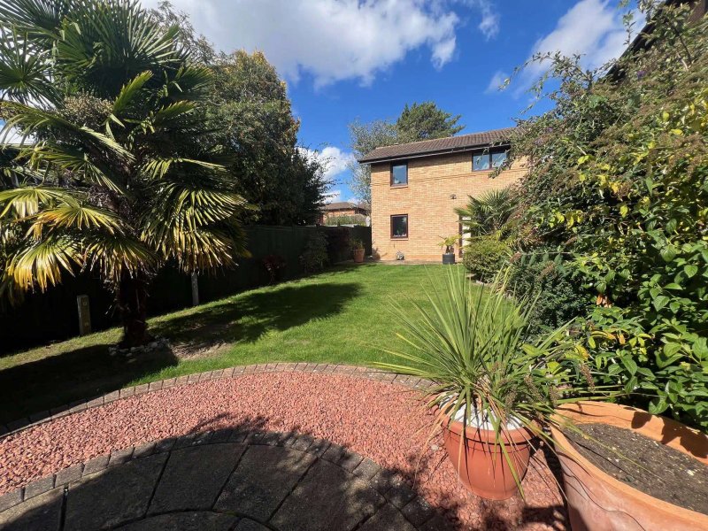 Brick house with garden, patio area, palm trees and mature landscaping