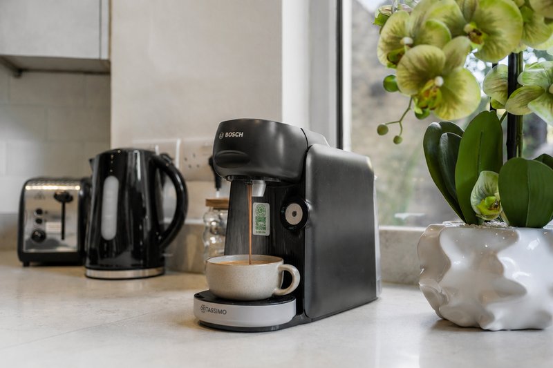 Kitchen counter with Bosch coffee maker, toaster, white pot with green flowers