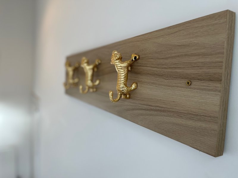 Wooden wall-mounted coat rack with brass decorative hooks