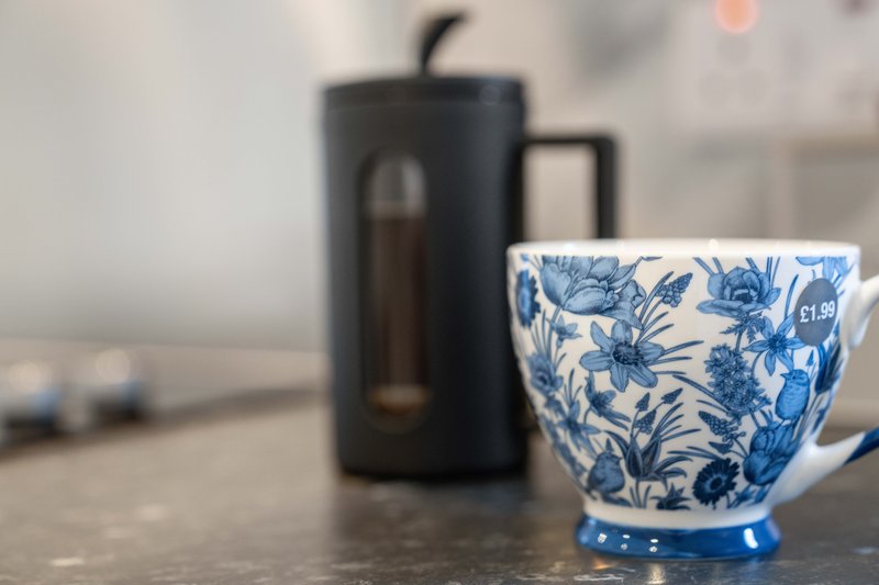 Kitchen counter with blue and white patterned mug and black electric kettle