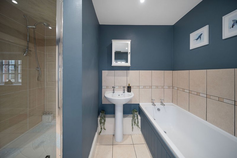 Modern bathroom with double sink, bathtub, walk-in shower and teal blue walls