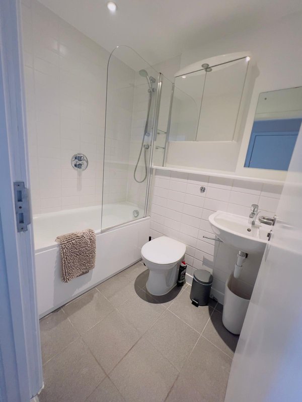 Clean modern bathroom with shower enclosure, white subway tiles, and vanity sink