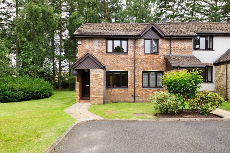 Brick semi-detached house with driveway, manicured garden and front entrance