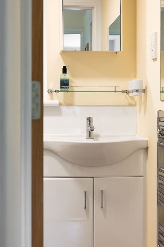 Modern bathroom with white vanity sink, mirror, and chrome fixtures