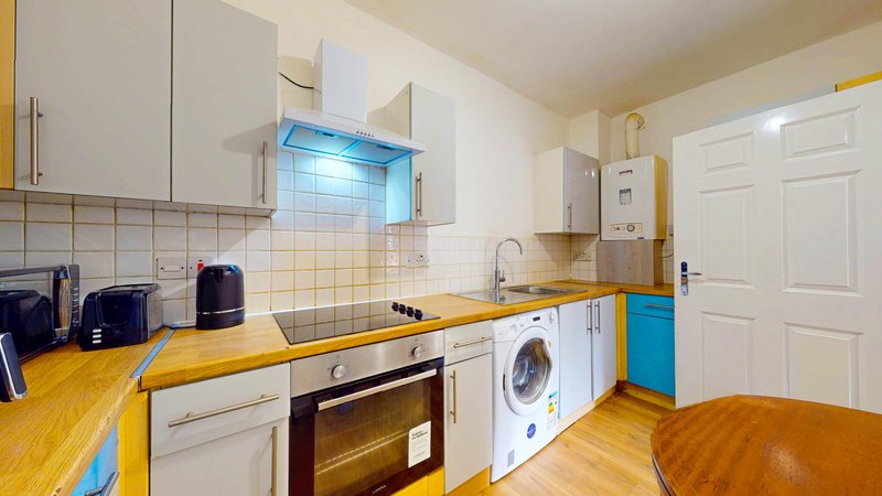 Modern kitchen with white cabinets, yellow countertops, integrated appliances and blue accents