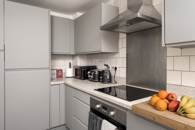 Modern kitchen with white cabinetry, stainless steel appliances, subway tile backsplash, and fresh fruit on countertop