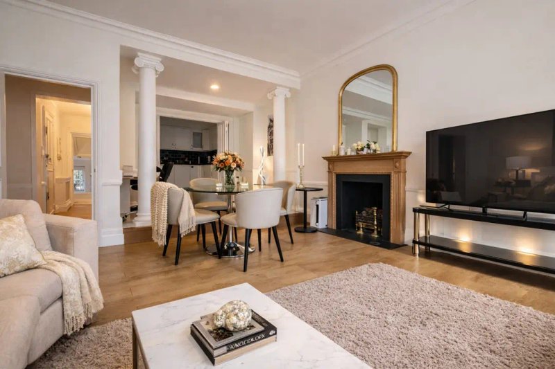 Spacious living room with fireplace, dining area, TV, and modern furnishings