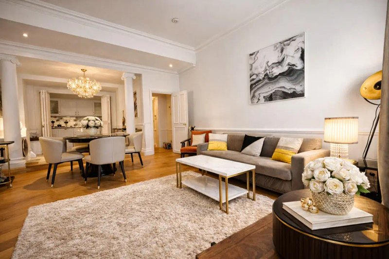 Spacious open-plan living room with grey sofa, dining area, wooden floors and modern decor