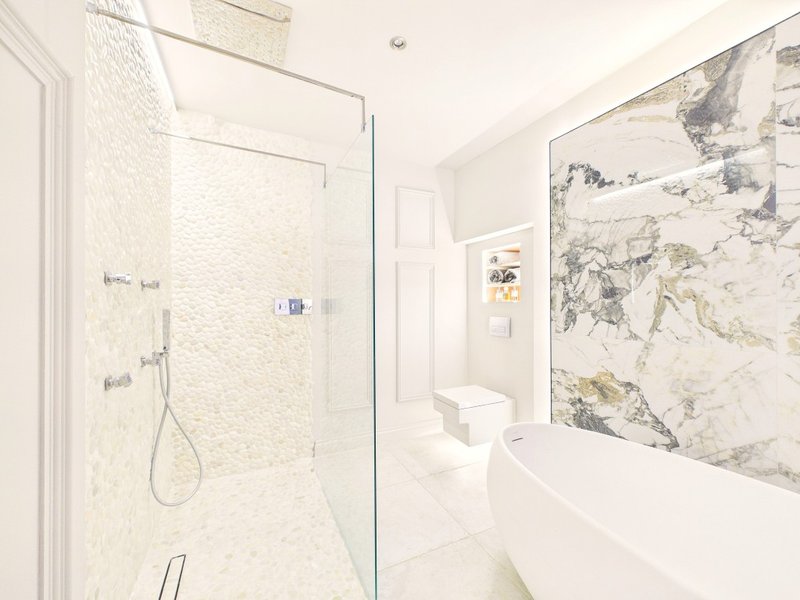 Modern bathroom with walk-in shower, white bathtub, marble-effect wall tiles and world map artwork