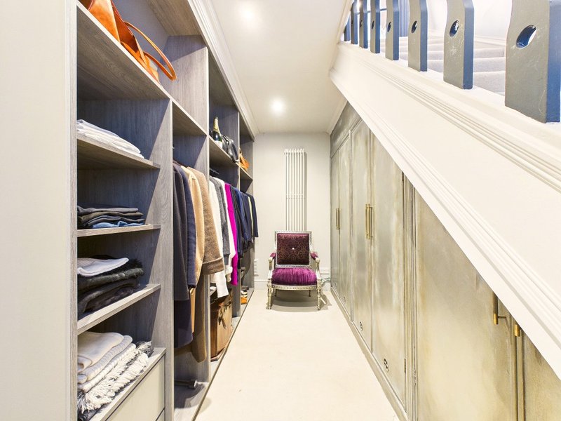 Walk-in closet with built-in shelving, hanging rails, and organized clothing storage