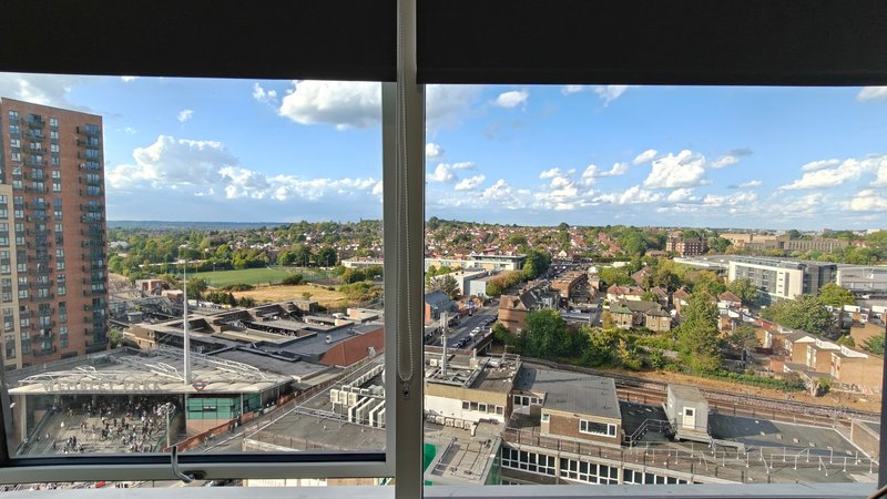Urban landscape view from high-rise window showing residential buildings, streets and blue sky