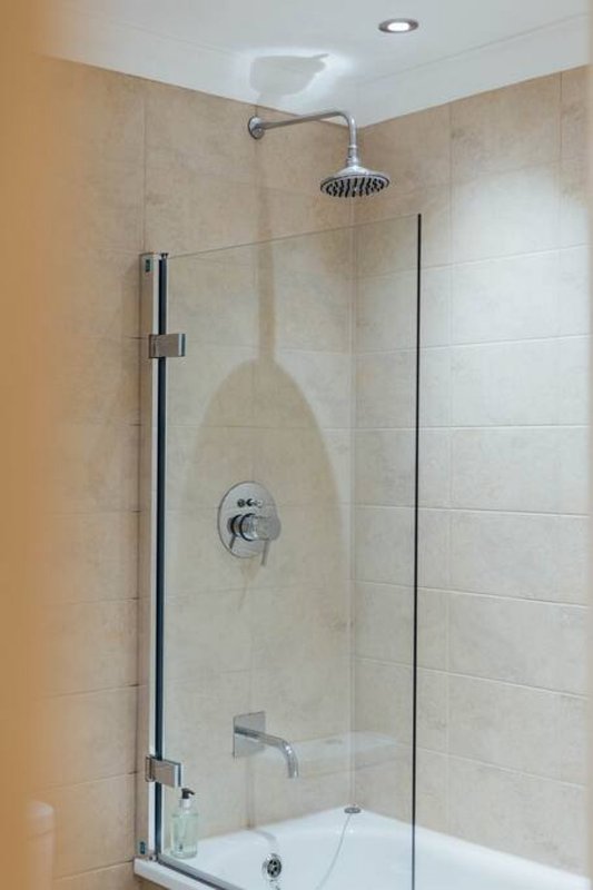 Modern bathroom with walk-in shower, glass screen, rainfall showerhead and tiled walls