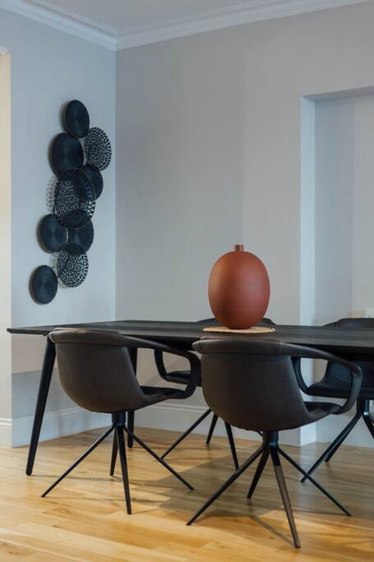 Dining area with black table, chairs, and red decorative sphere on top