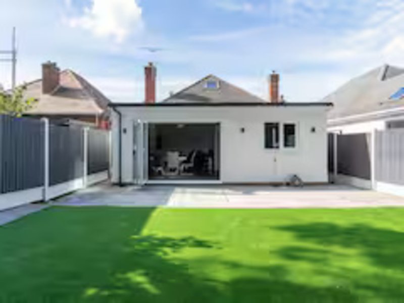 Modern single-story house with open-plan living, manicured lawn, and contemporary exterior design