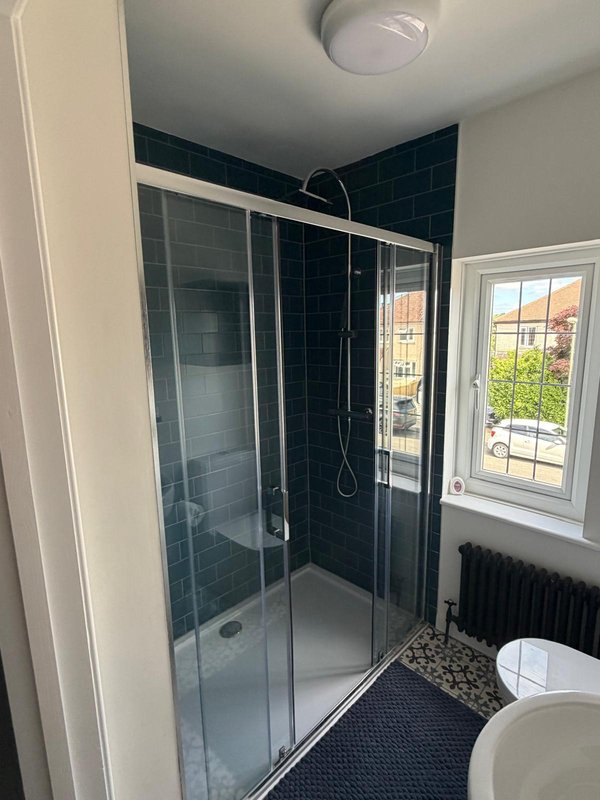 Modern bathroom with dark tile shower enclosure, toilet, ensuite to room 1