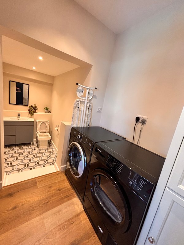 Laundry room with black front-load washers, dryer, and Downstairs WC