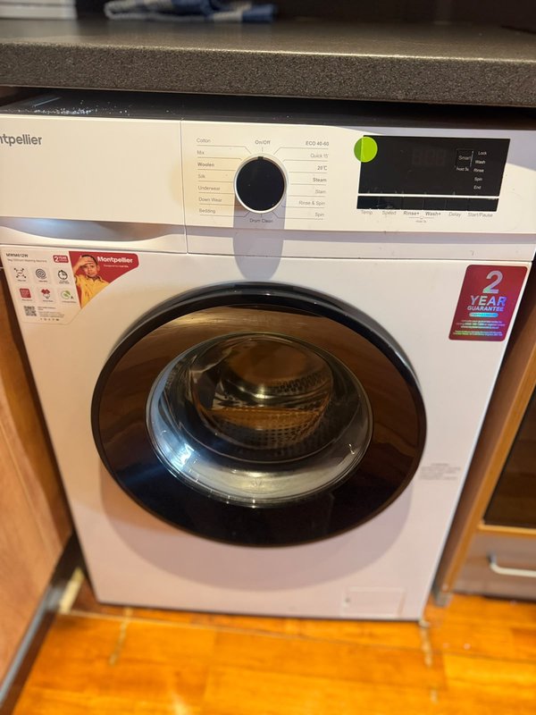 Modern white front-loading washing machine with control panel and open door