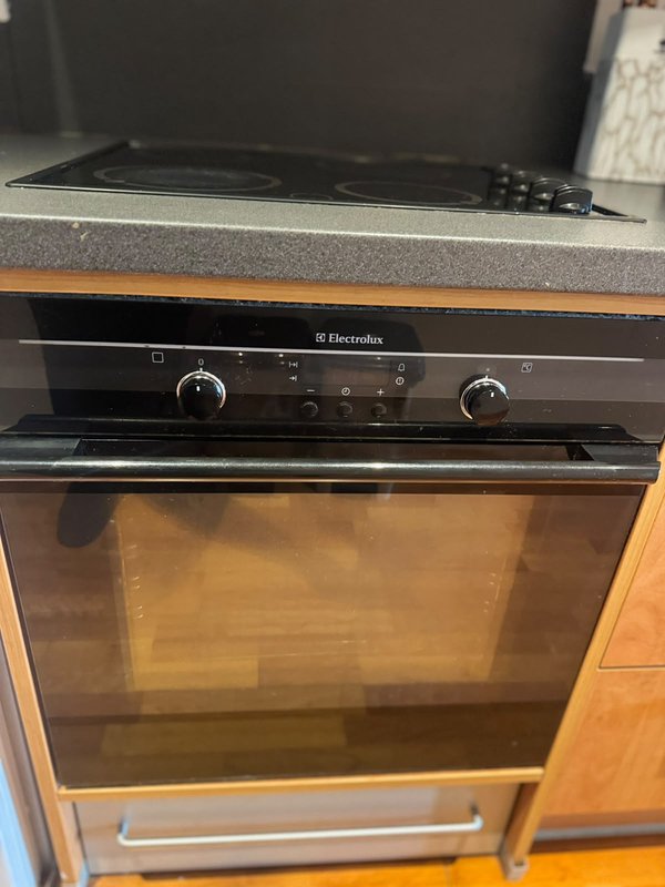 Built-in electric oven with black frame and glass door in kitchen cabinetry
