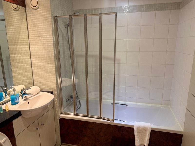 Bathroom with sink, mirror, shower enclosure and towel rail