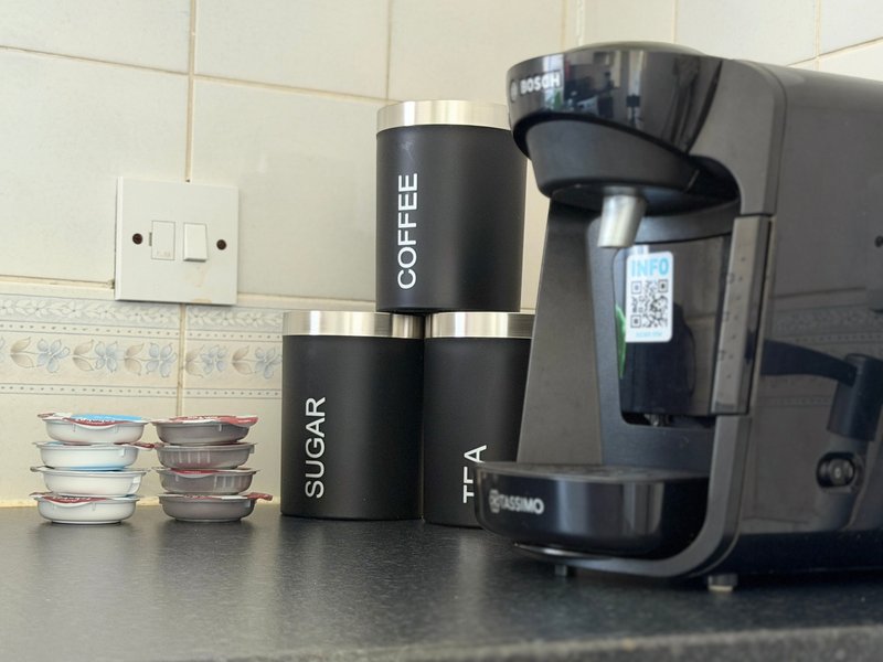 Kitchen countertop with coffee maker, labeled containers, and small appliances