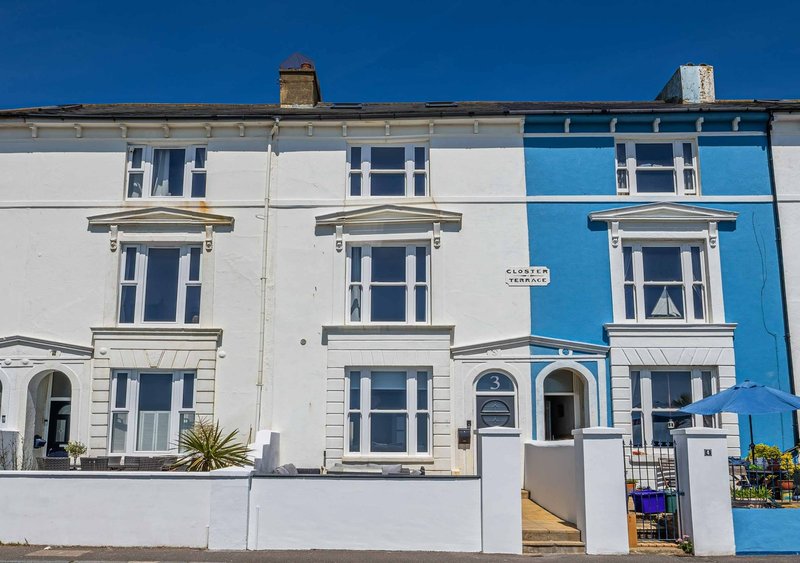 Row of Victorian terraced houses with white and blue facades, sash windows and front gates