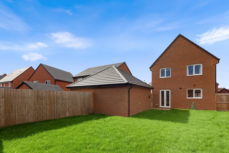 Brick detached house with green lawn, wooden fence, and neighbouring properties visible
