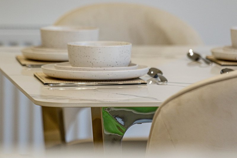 Minimalist dining table set with neutral dishware, napkins and place settings