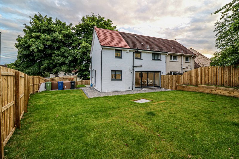 Modern semi-detached house with brick and render, large garden, wooden fence and patio area