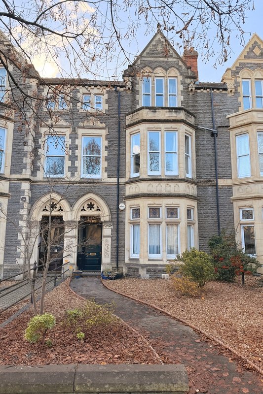 Victorian stone terraced house with bay windows, gravel driveway and front garden