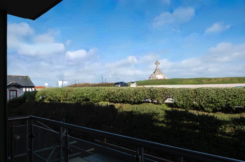 Rural countryside view from property balcony with hedgerow, fields and distant church