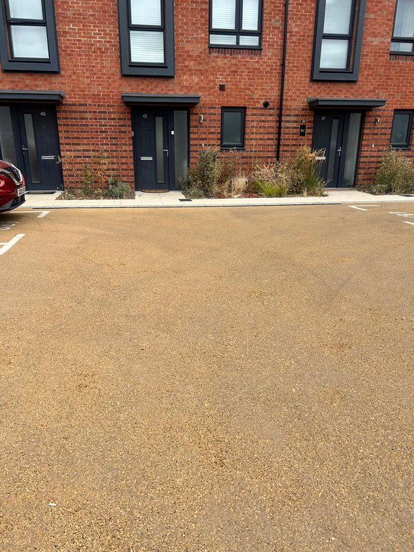 Modern brick townhouse exterior with driveway, multiple black doors and windows