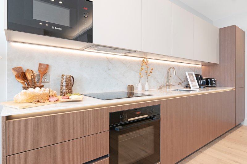 Modern kitchen with wood cabinetry, marble backsplash, integrated appliances and countertop styling