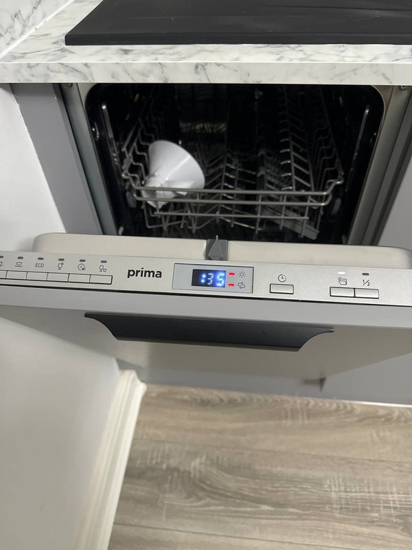 Built-in dishwasher with white marble countertop and wooden cabinet below
