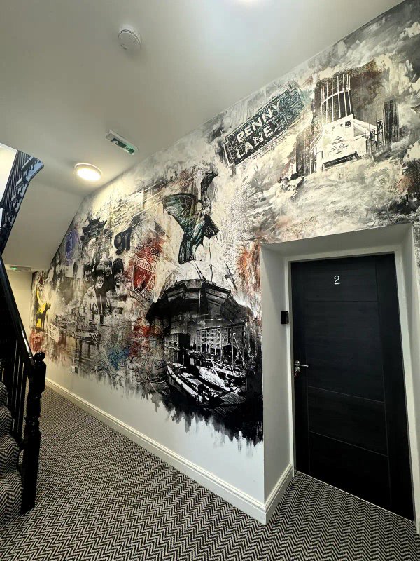 Hallway with large artistic wall mural, black door marked with number 2