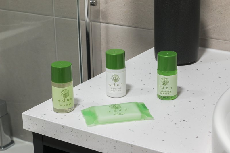Modern bathroom counter with toiletries bottles, soap dispenser and hand towel