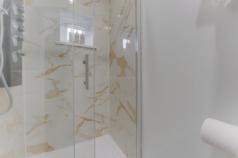 Modern bathroom with marble-effect tiled shower enclosure and glass door