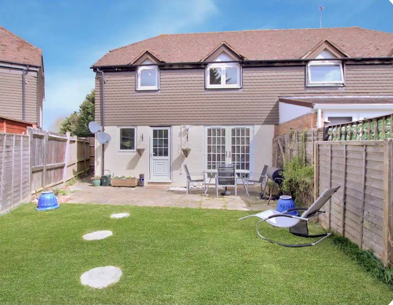 Semi-detached house rear garden with lawn, patio seating area and wooden fencing