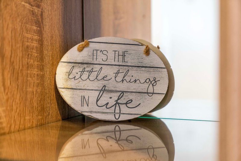 Wooden decorative sign with handwritten text on polished table surface