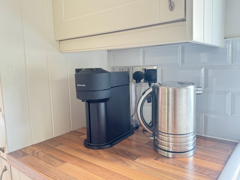 Kitchen counter with black coffee maker and stainless steel electric kettle