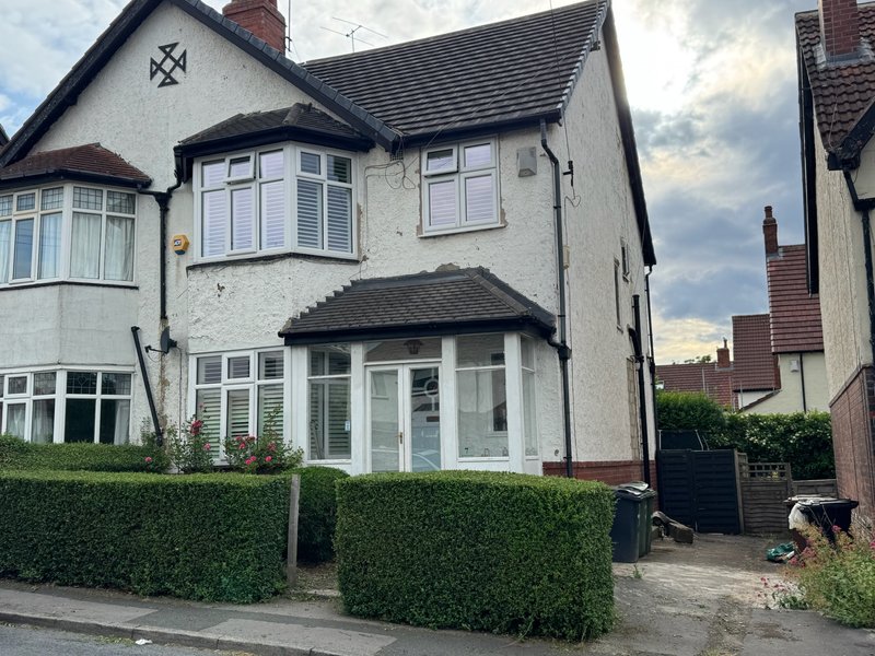 Exterior of two-storey semi-detached house with bay window and brick chimney
