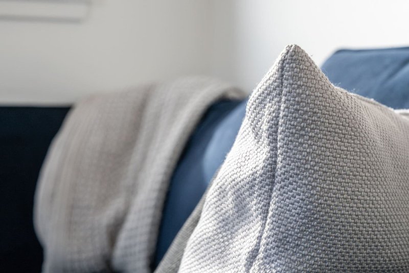 Close-up of folded textiles and cushions on upholstered furniture
