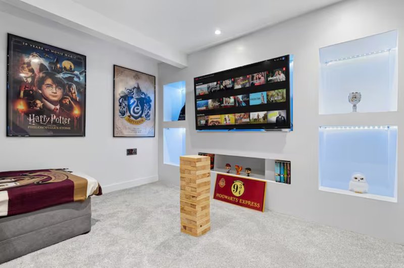 Game room with Harry Potter poster, shelving unit, Jenga blocks, and red decorative box