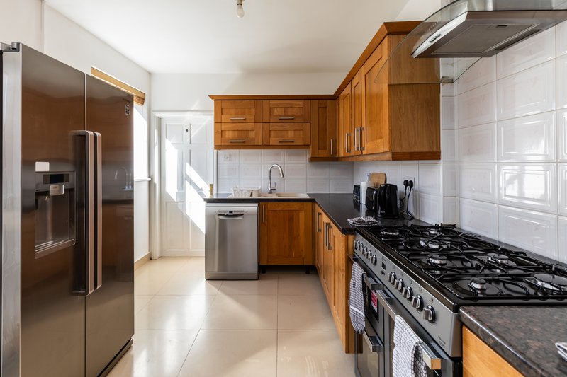 Modern kitchen with wooden cabinets, stainless steel appliances, gas range and tiled backsplash