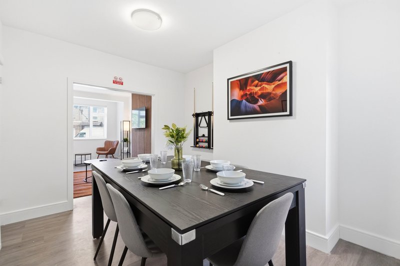 Modern dining room with black table, grey chairs, and place settings