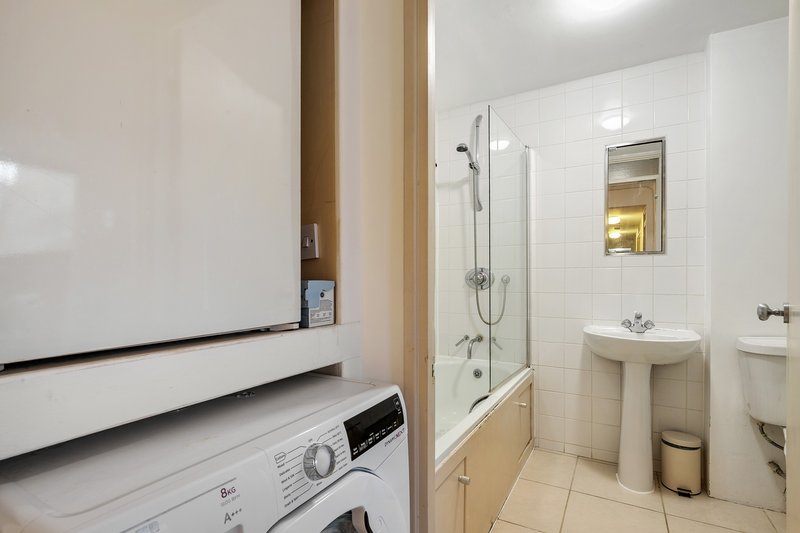 Modern bathroom with shower enclosure, pedestal sink, toilet and washing machine
