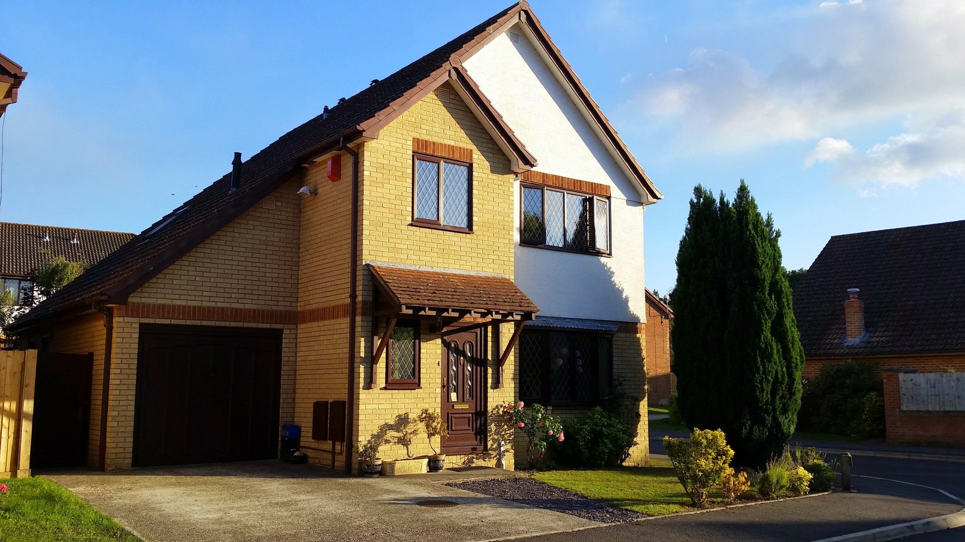 Two-storey detached house with garage, driveway, and landscaped front garden
